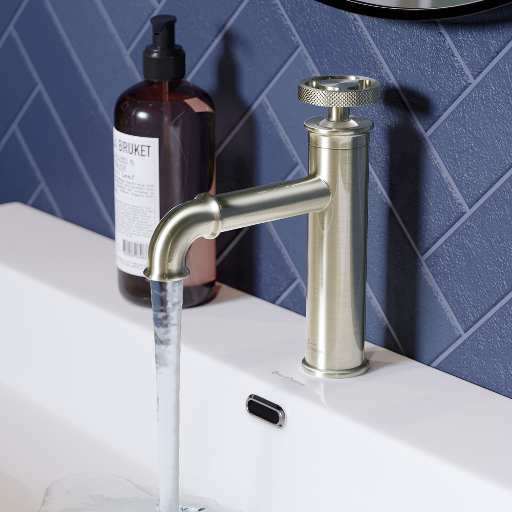 Single-handle bathroom faucet in brushed nickel with wheel handle and cylindrical base.