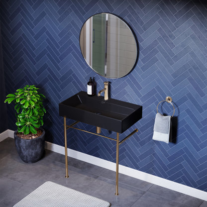 Small ceramic console sink with matte black basin and gold legs, modern rectangular design.