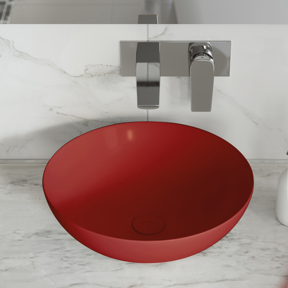 Round vessel ceramic bathroom sink in matte red with wall-mounted chrome faucet.