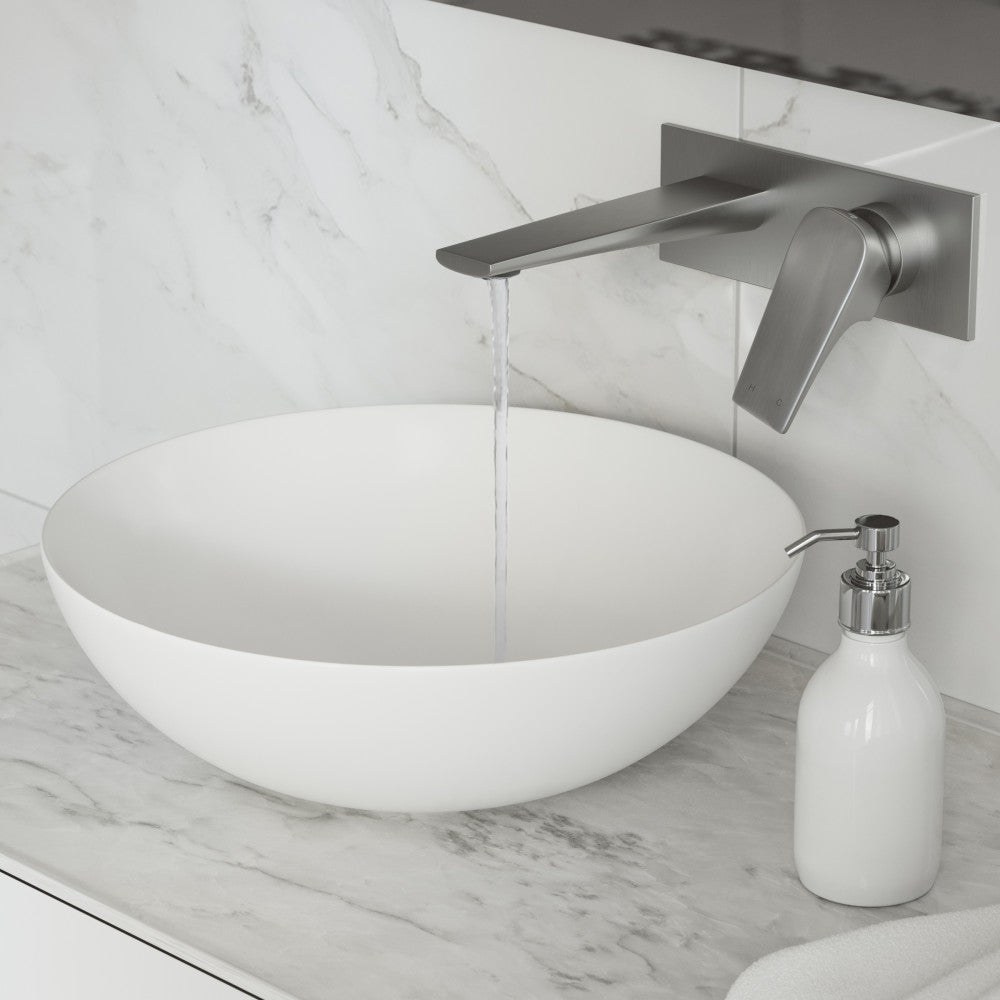 Wall-mount bathroom faucet in brushed nickel, single-handle, modern angular design with water flowing from spout.
