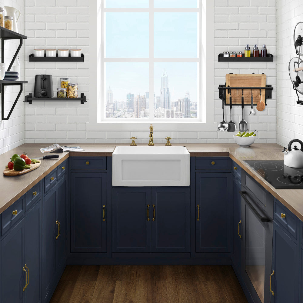 24 x 18 white ceramic farmhouse kitchen sink with apron front installed in navy blue cabinetry.