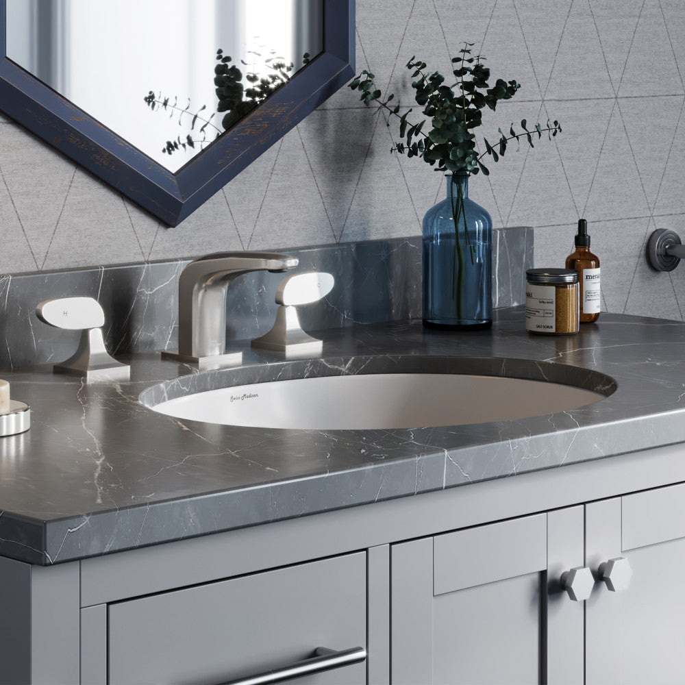 18-inch oval undermount bathroom sink in white with gray marble countertop and chrome faucet.