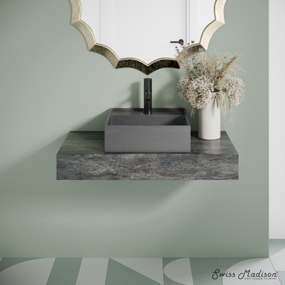 16" square concrete vessel bathroom sink in dark grey with matte black faucet on floating countertop.