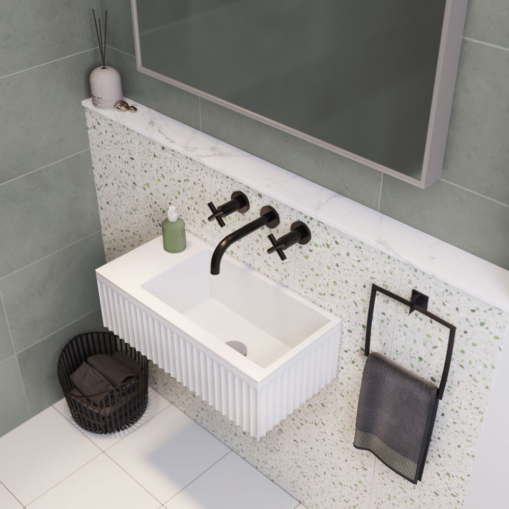 24-inch matte white rectangular wall-mount bathroom sink with vertical ridged texture and black wall-mounted faucet.