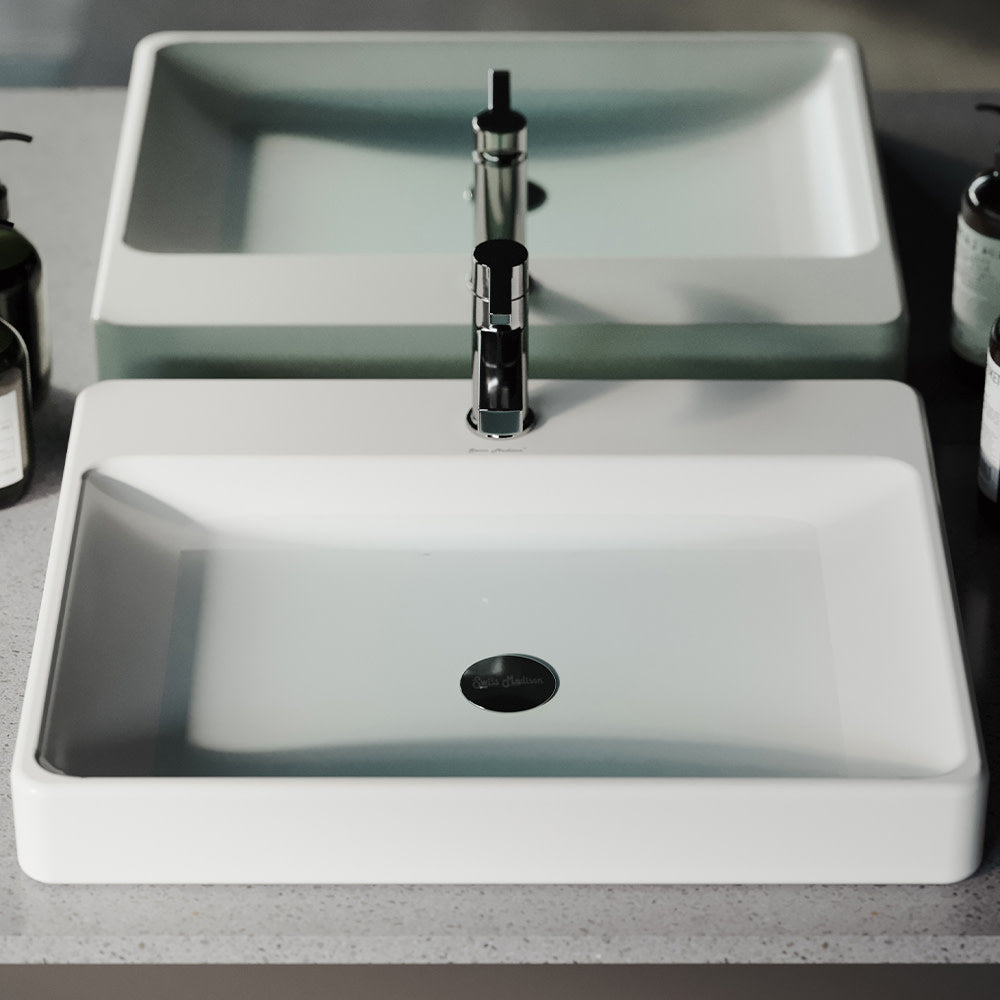 Large white rectangular vessel sink with sleek edges and black drain hole.