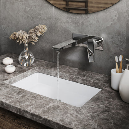 Wall-mount single-handle bathroom faucet in chrome with water flowing over rectangular white sink.
