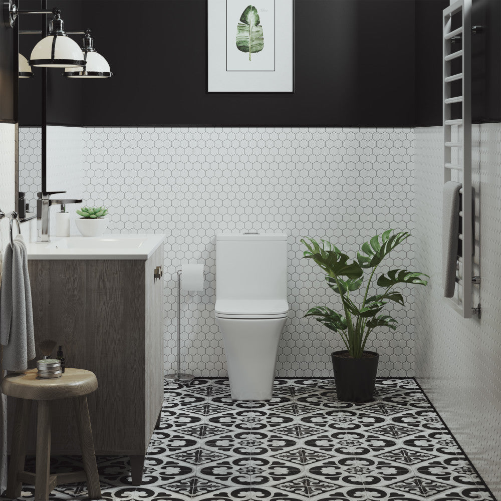 Elongated one-piece toilet with dual-flush button, compact design in white porcelain.
