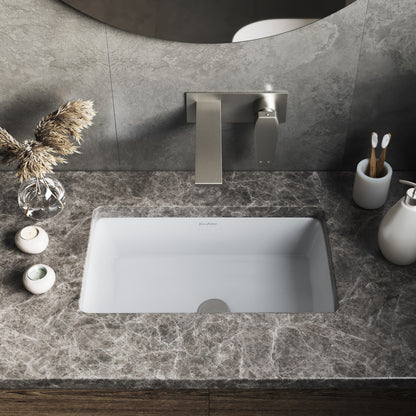 Rectangular white under-mount bathroom sink installed in gray marble countertop with modern wall-mounted faucet.