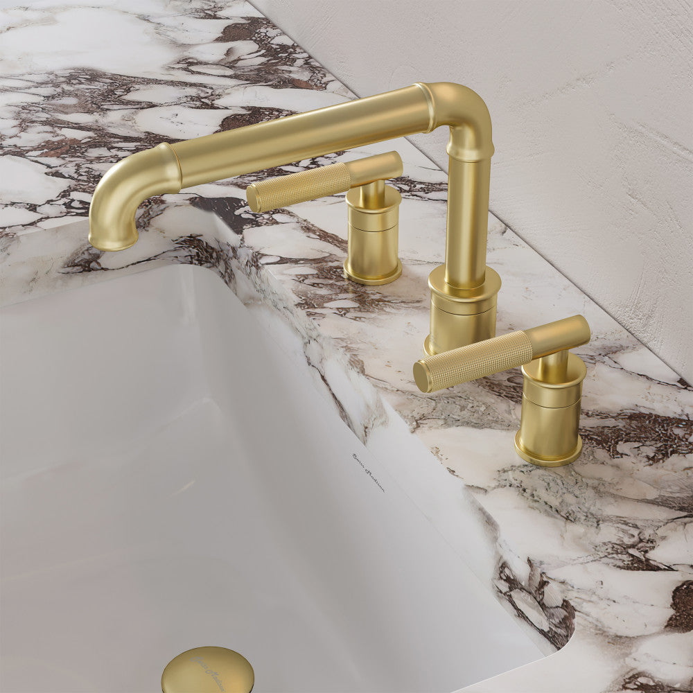Widespread bathroom faucet in brushed gold with sleek dual handles and curved spout on marble countertop.