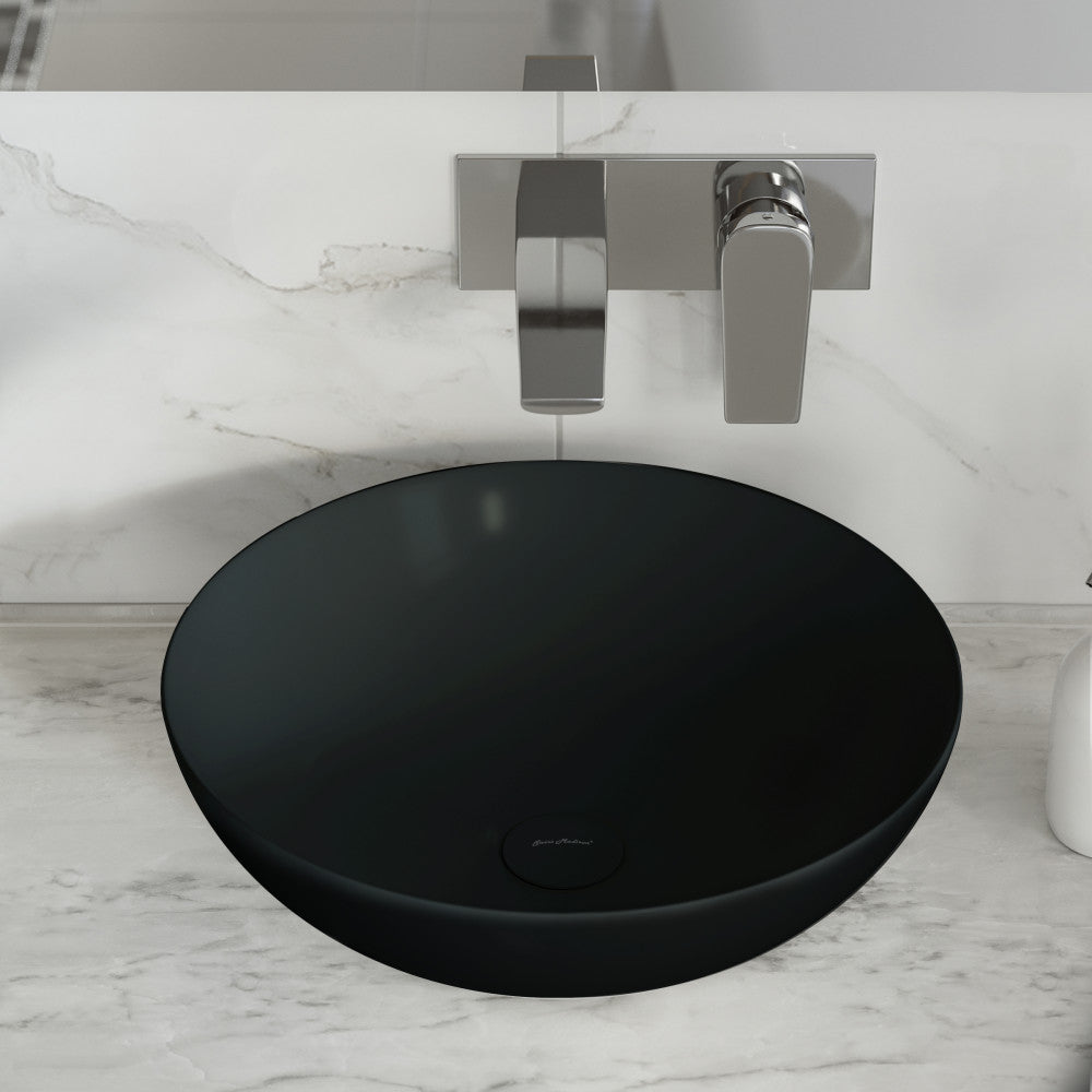 Matte black ceramic vessel sink with round shape and smooth matte finish on marble countertop.