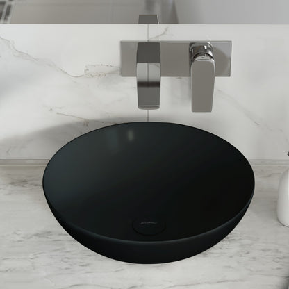 Matte black ceramic vessel sink with round shape and smooth matte finish on marble countertop.