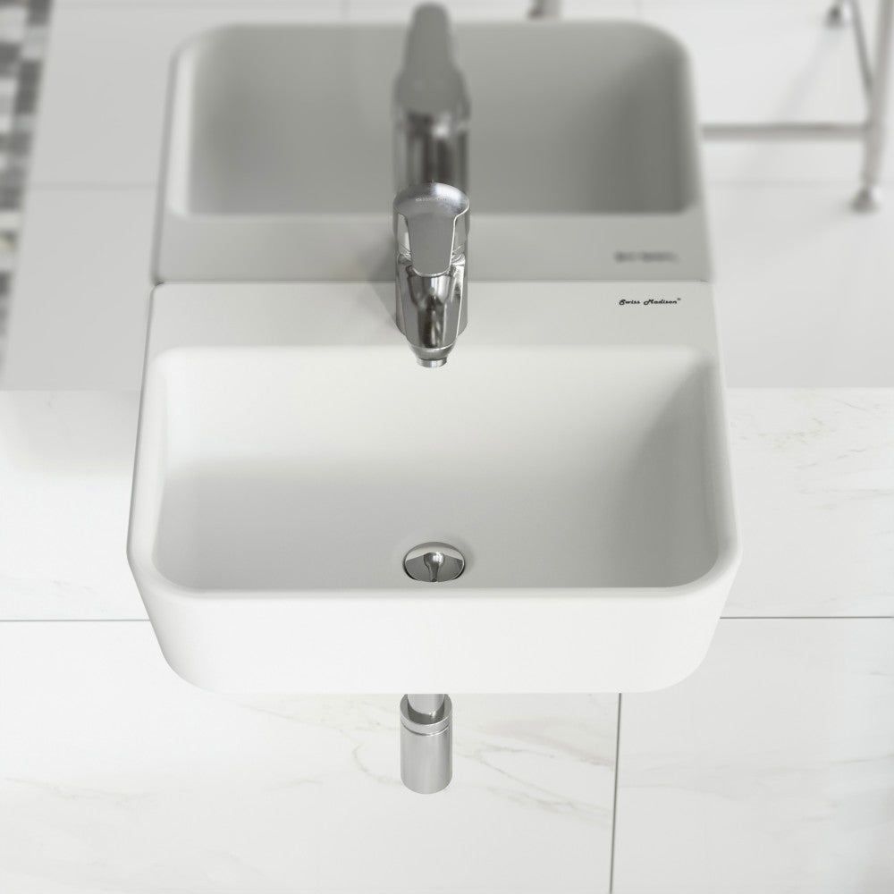 Small rectangular white wall-mount bathroom sink with single faucet hole and round drain.