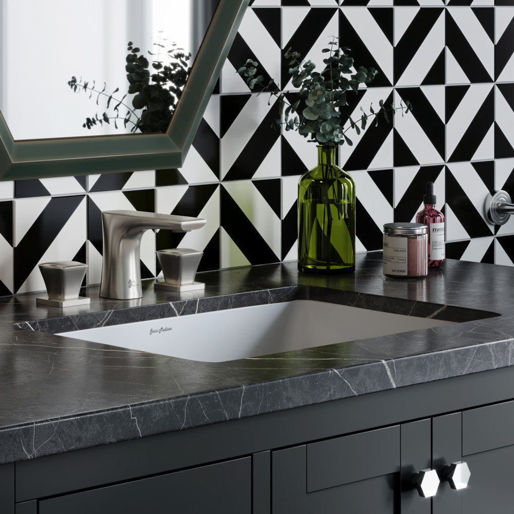 Rectangular undermount bathroom sink with white basin and dark countertop, modern faucet, geometric black and white tile.