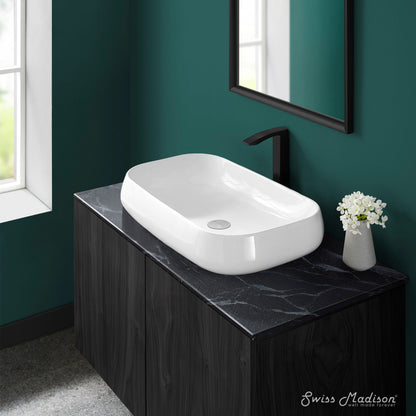 White rectangular ceramic vessel sink with smooth rounded edges on black marble countertop.