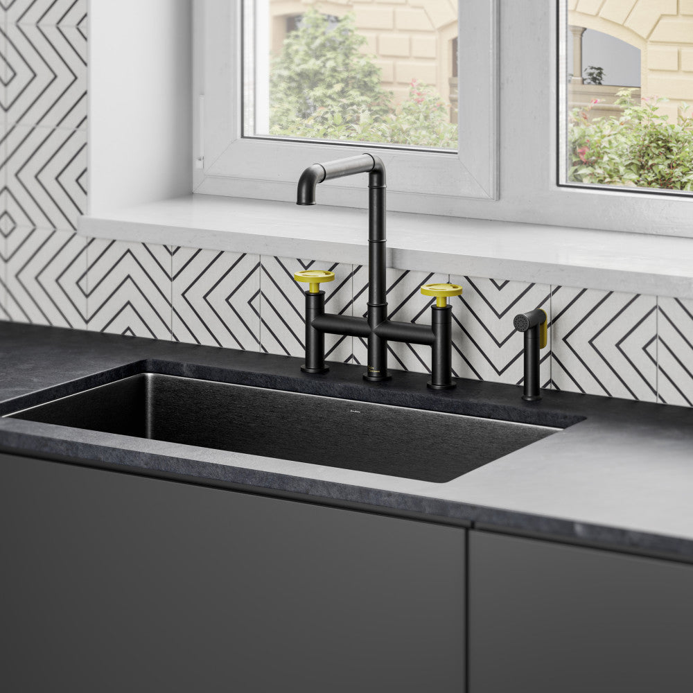 Widespread kitchen faucet in matte black with yellow handles, tall curved spout.