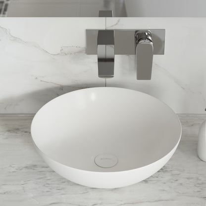 Shiny white ceramic vessel sink with round shape on marble countertop and wall-mounted chrome faucet.