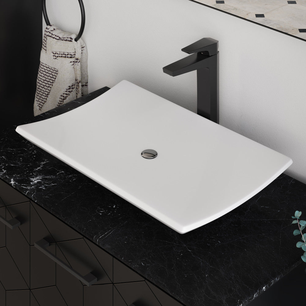 23.5” rectangular white ceramic vessel bathroom sink with centered drain on black countertop.
