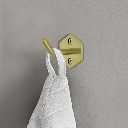 Brushed gold robe hook with hexagonal base mounted on gray wall holding white towel.