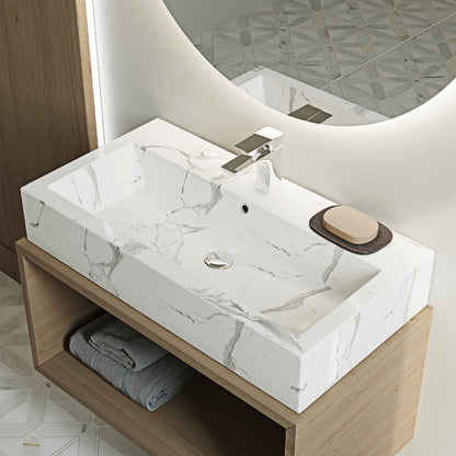 Wide rectangular vessel sink in white marble with sleek polished surface and subtle gray veining.