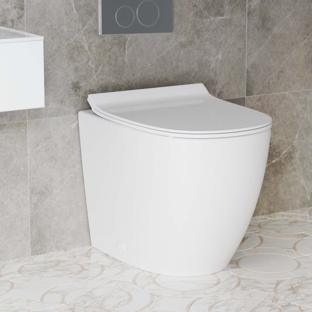 Elongated back-to-wall toilet in glossy white with concealed tank and soft-close seat.