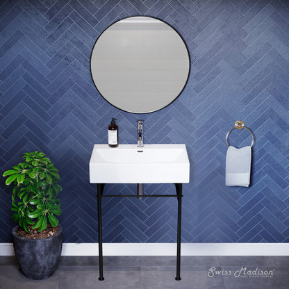 Small white console sink with black metal legs, round mirror, mounted faucet, blue herringbone tile wall.